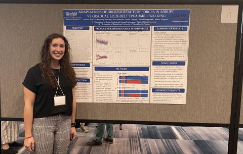 Photo of female student in front of presentation board