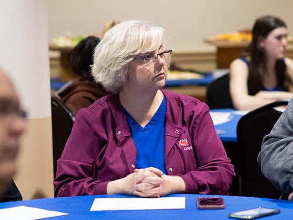 A student sitting at a table and paying attention in a seminar setting.