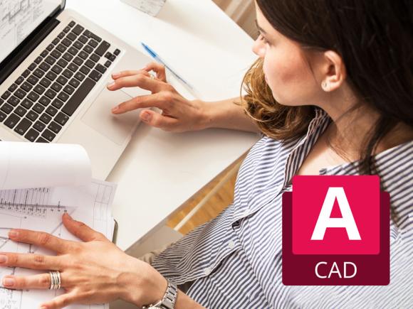 Person reviewing architectural blueprints while working on a laptop with CAD software.