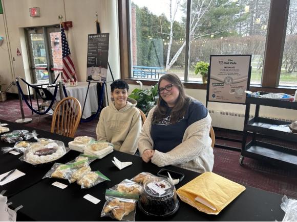 Two students from the nursing department's Psychiatric Nursing class hosting a bake sale in the Dining Commons as part of their final project.