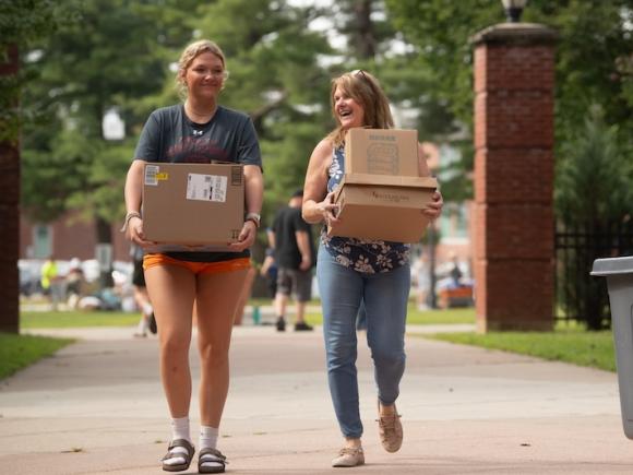 A female student and her mother carrying boxes as part of Move-In Day.