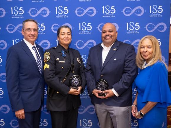 Firefighter Jon-Randel Quarles and Police Sergeant Juanita Mejias from the City of Westfield holding their awards from the Keeper of the Dream dinner, alongside President Thompson of Westfield State and Westfield Mayor Mike McCabe.