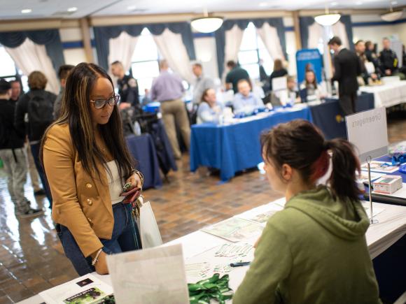 Student speaking with an employer at a career fair.