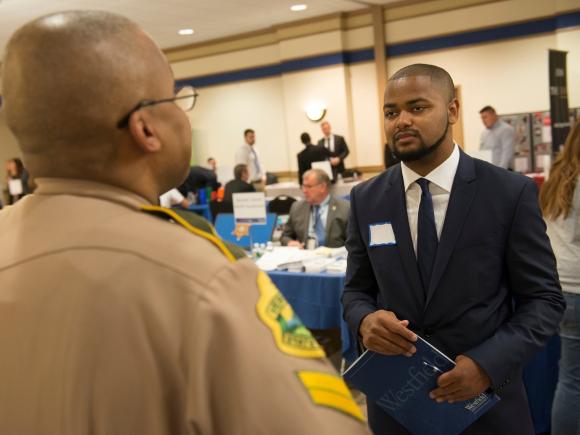 Student talking to an employer at an internship and job fair.