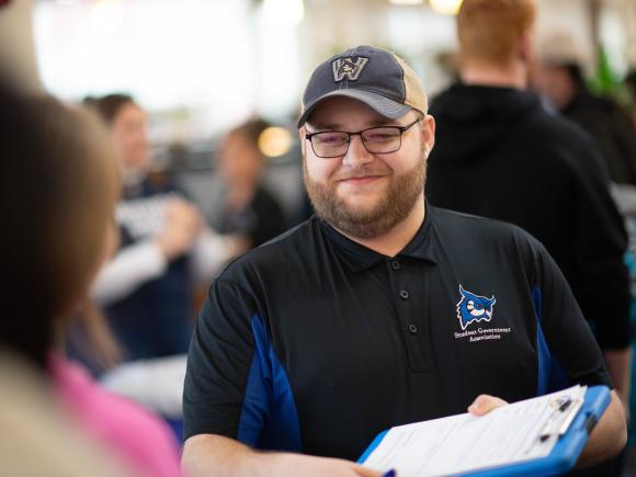 Student Government member smiling while having a conversation with a fellow student.