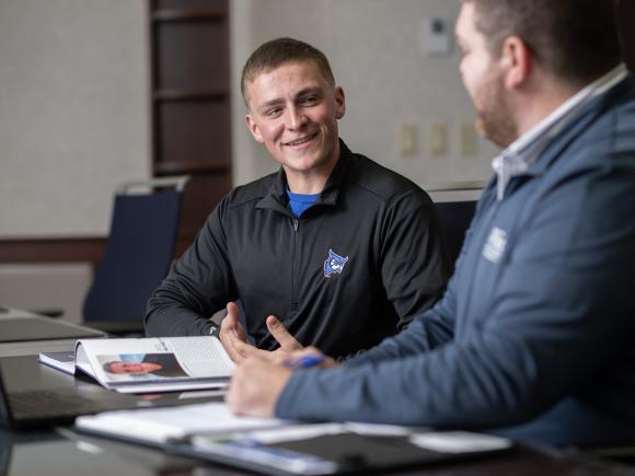 Matt Crusha ’27 talks with Ryan Meersman ’12 during his internship in Westfield State’s Alumni Relations Office.