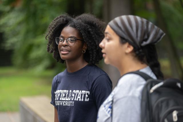 Political Science student smiling outside on campus green.