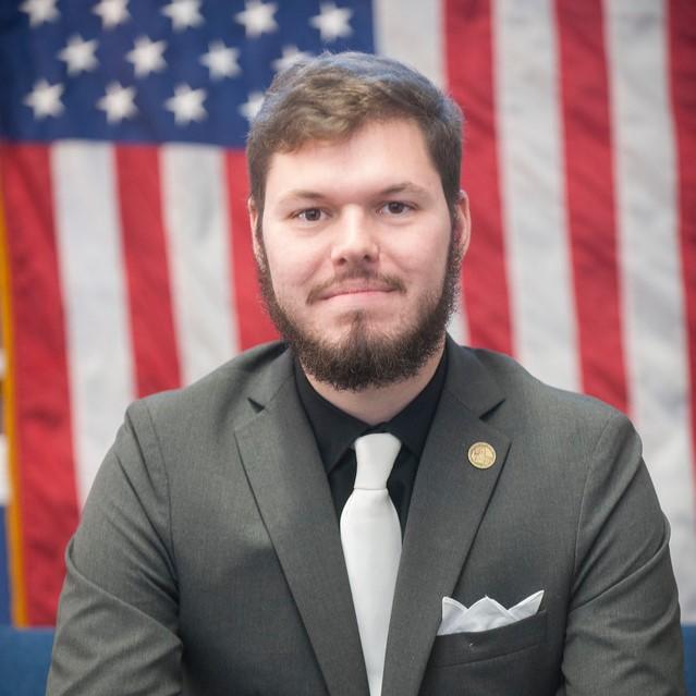 Student interning with House of Representatives, dressed in a suit and tie.