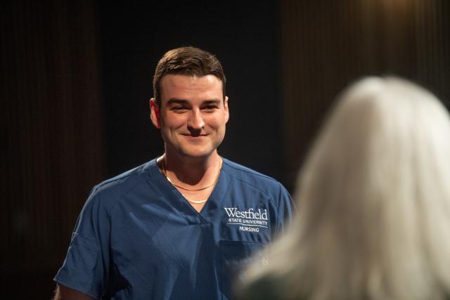 Student smiling at nursing commencement event.