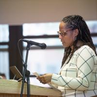 Dr. H. Zahra Caldwell, Chair and Associate Professor of Ethnic and Gender Studies, speaking at a podium for an event held in the Scanlon Banquet Hall that discussed violence against black and indigenous peoples.